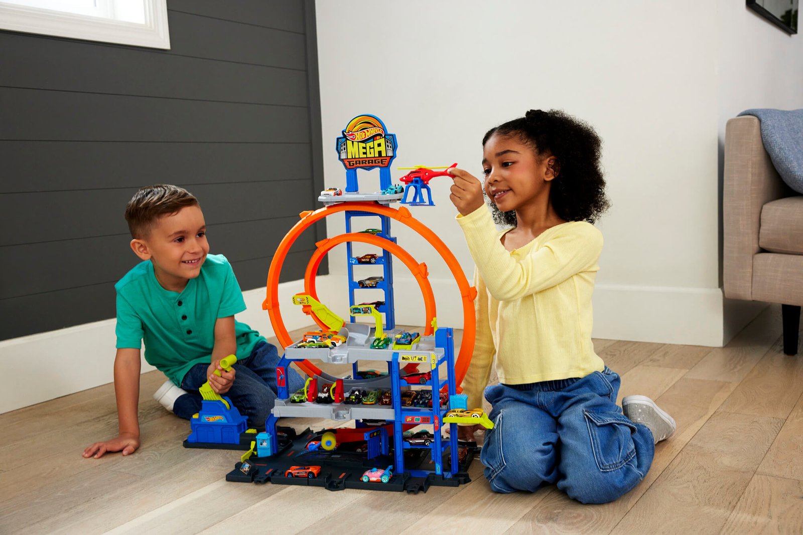 Berniukas ir mergaitė žaidžia su Hot Wheels City garažu