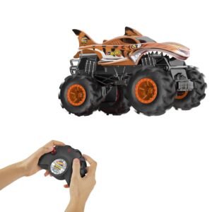Hot Wheels RC monstrų sunkvežimis „Tiger Shark“ su tigro dryžiais ir ryklio nasrais, šalia – pultelis