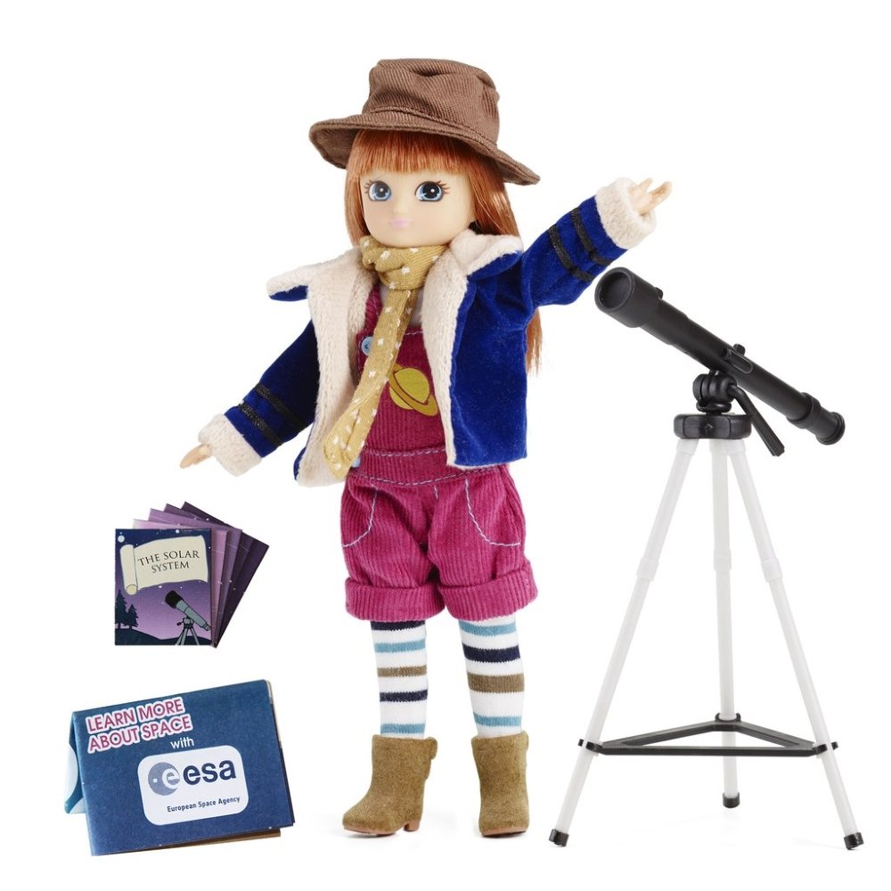 Lėlė astronomė Lottie su ruda skrybėle, mėlyna striuke ir vyšniniu kombinezonu šalia juodo teleskopo ant balto trikojo ir kolekcinių kortelių