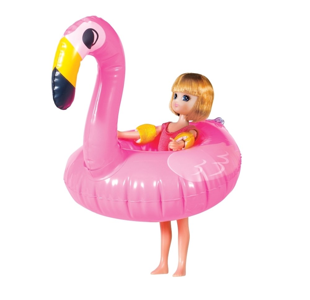 Lottie lėlė sėdi pripučiamo flamingo rato viduje