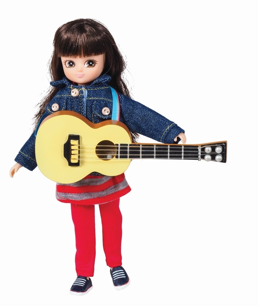Lottie lėlė laiko akustinę gitarą ant mėlyno dirželio