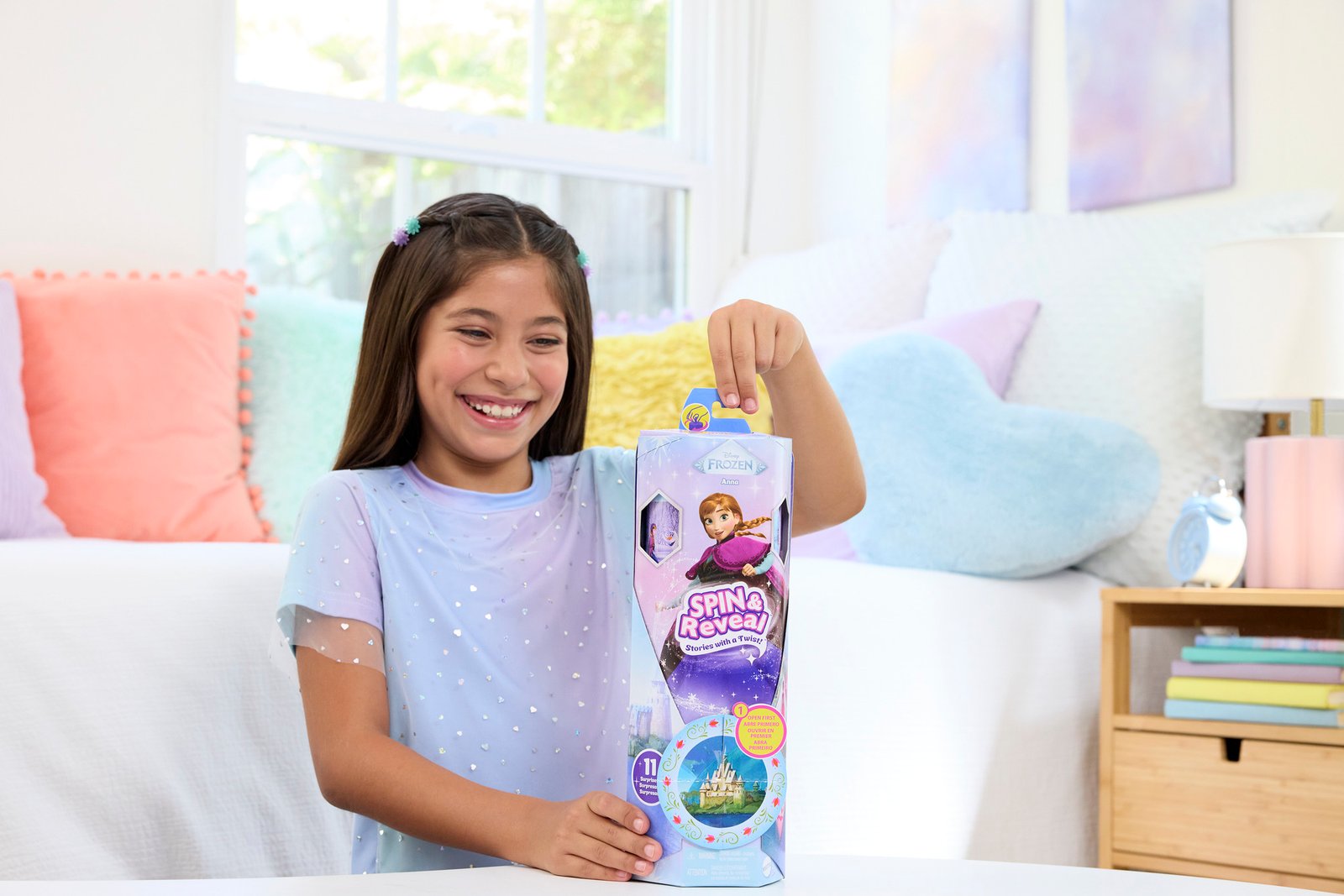 Mergaitė laiko aukštą Frozen Spin & Reveal dėžutę su Ana