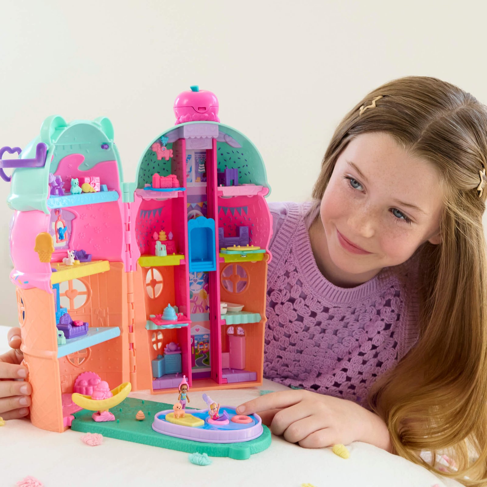 Mergaitė žaidžia su atverta Polly Pocket ledaine