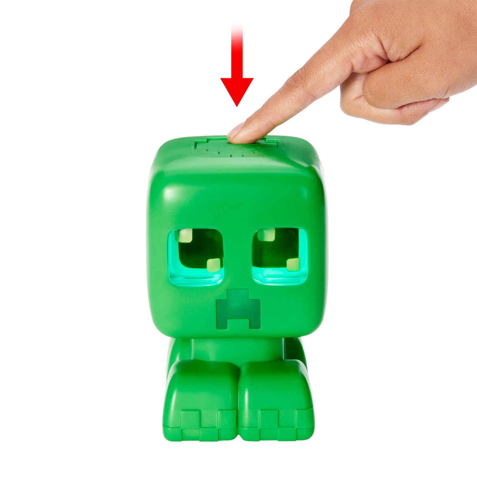 Creeper akys šviečia žydra spalva, pirštas spaudžia mygtuką galvos viršuje