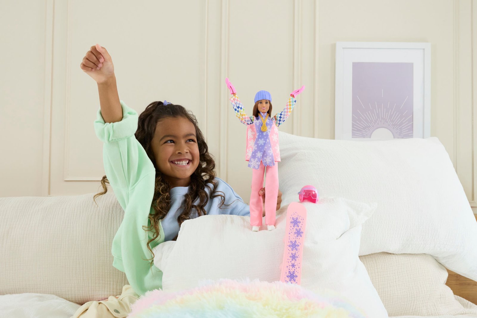 Mergaitė džiugiai žaidžia su Barbie snieglentininke namuose