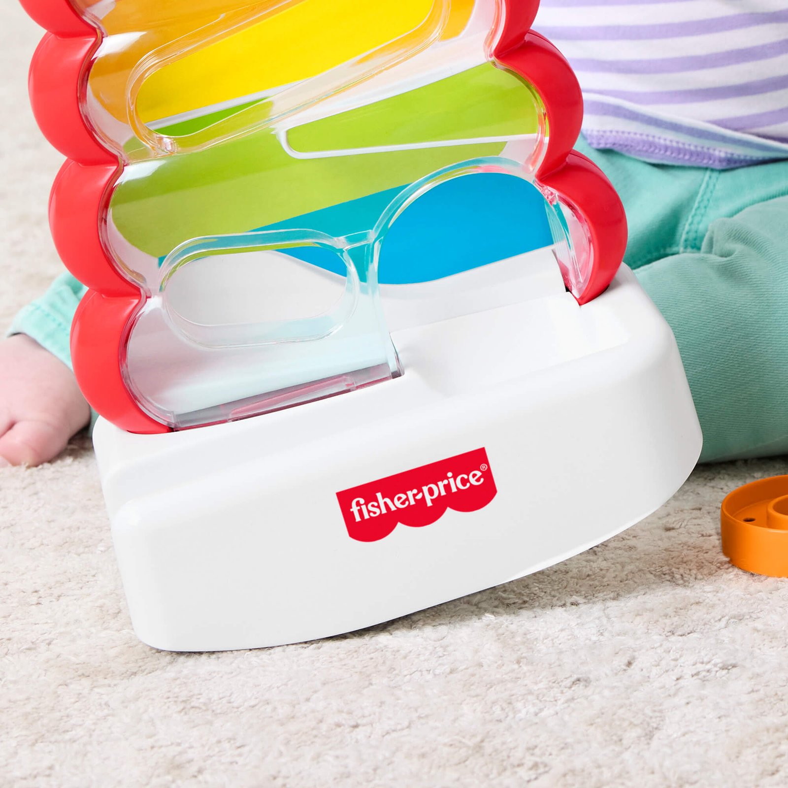 Baltas siūbuojantis bokštelio pagrindas su Fisher-Price ženklu iš arti