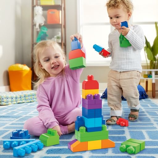 Iliustracinė nuotrauka: mažyliai ant kilimo žaidžia su Mega Bloks kaladėlėmis