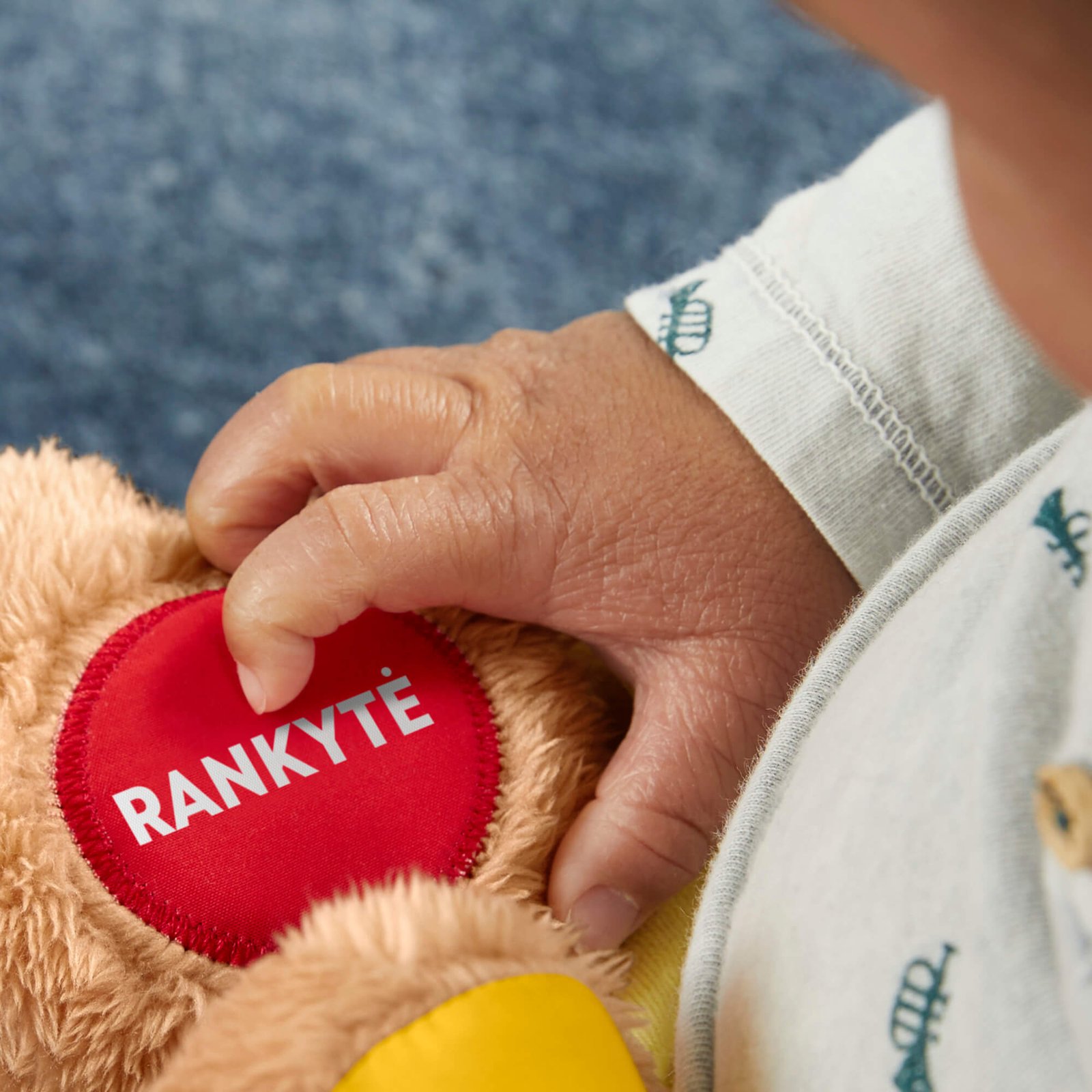 Raudona šuniuko rankytė su užrašu RANKYTĖ ir mažylio ranka