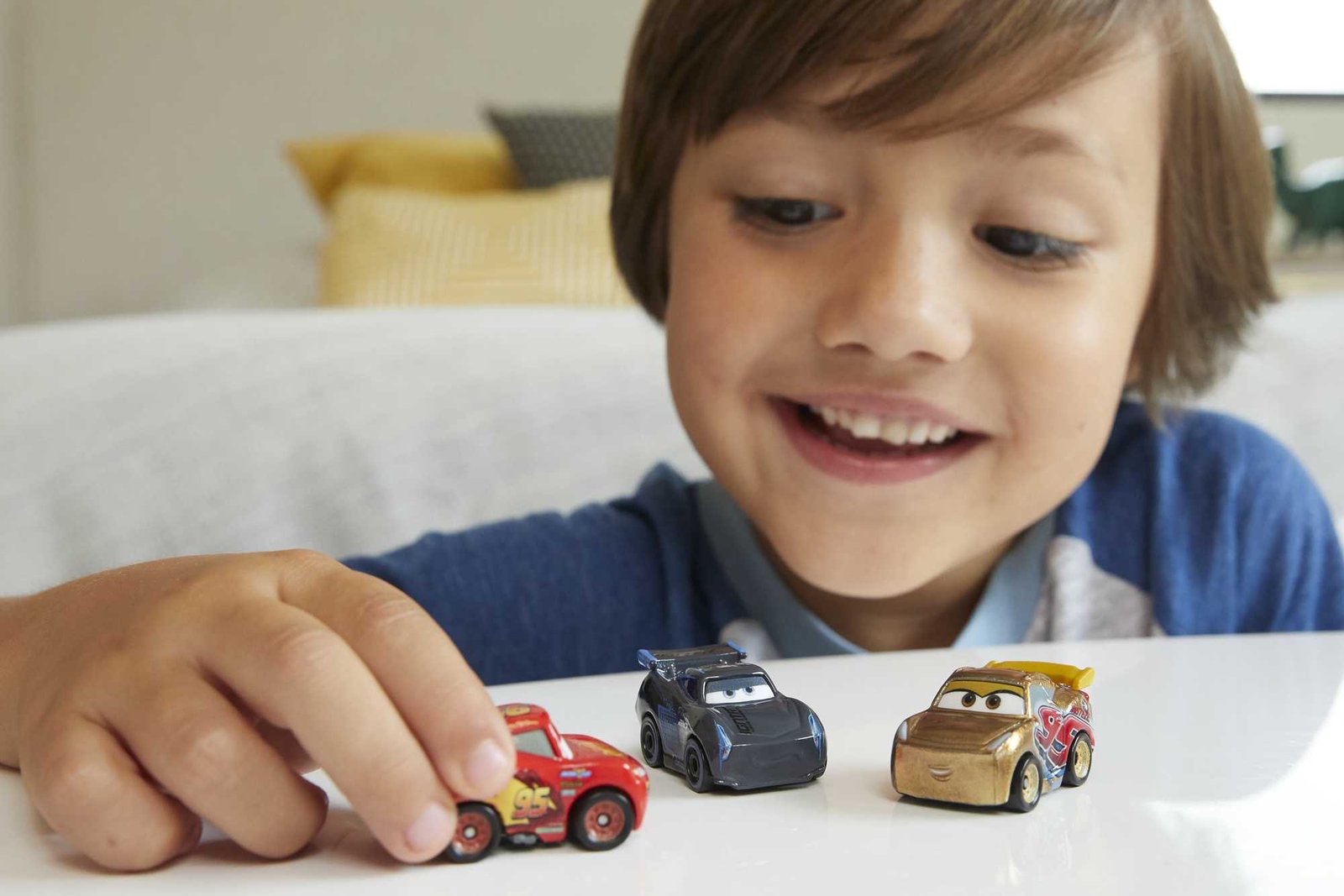 Berniukas žaidžia su mažytėmis Cars Mini Racers mašinėlėmis