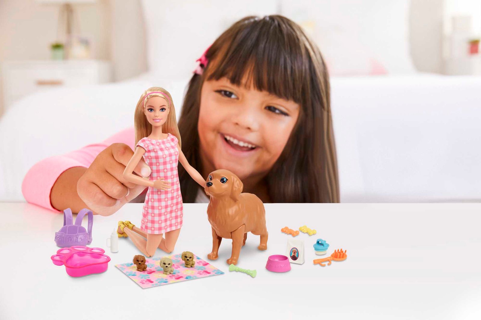 Mergaitė žaidžia su Barbie lėle, šunele mama ir šuniukais